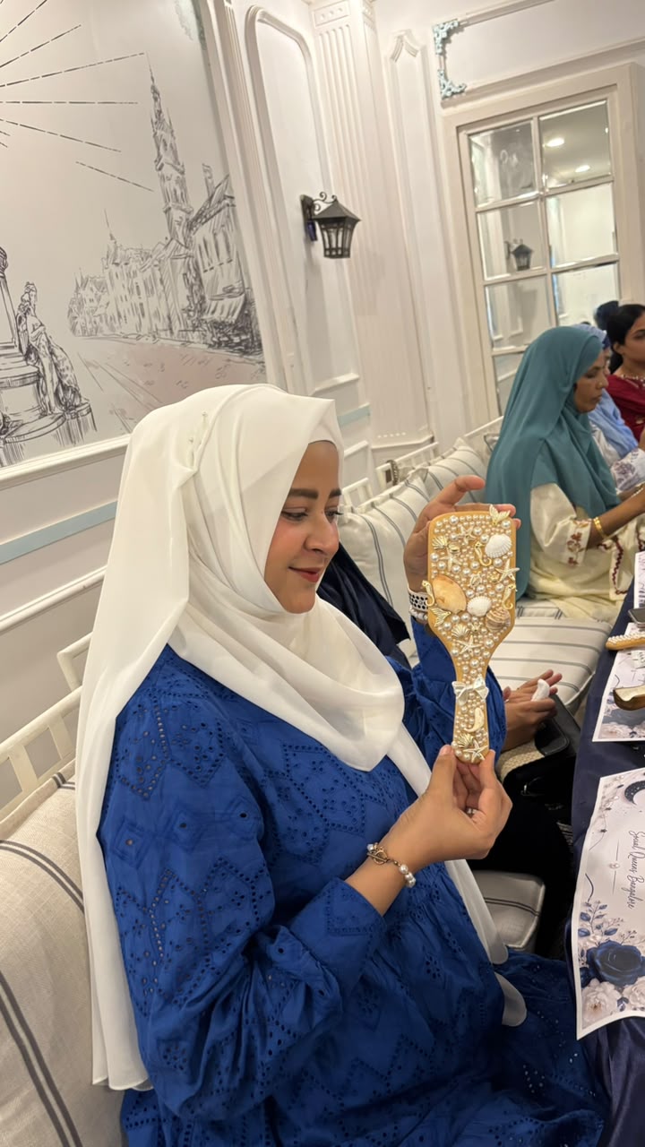 Queen holding a pearl decorated hairbrush