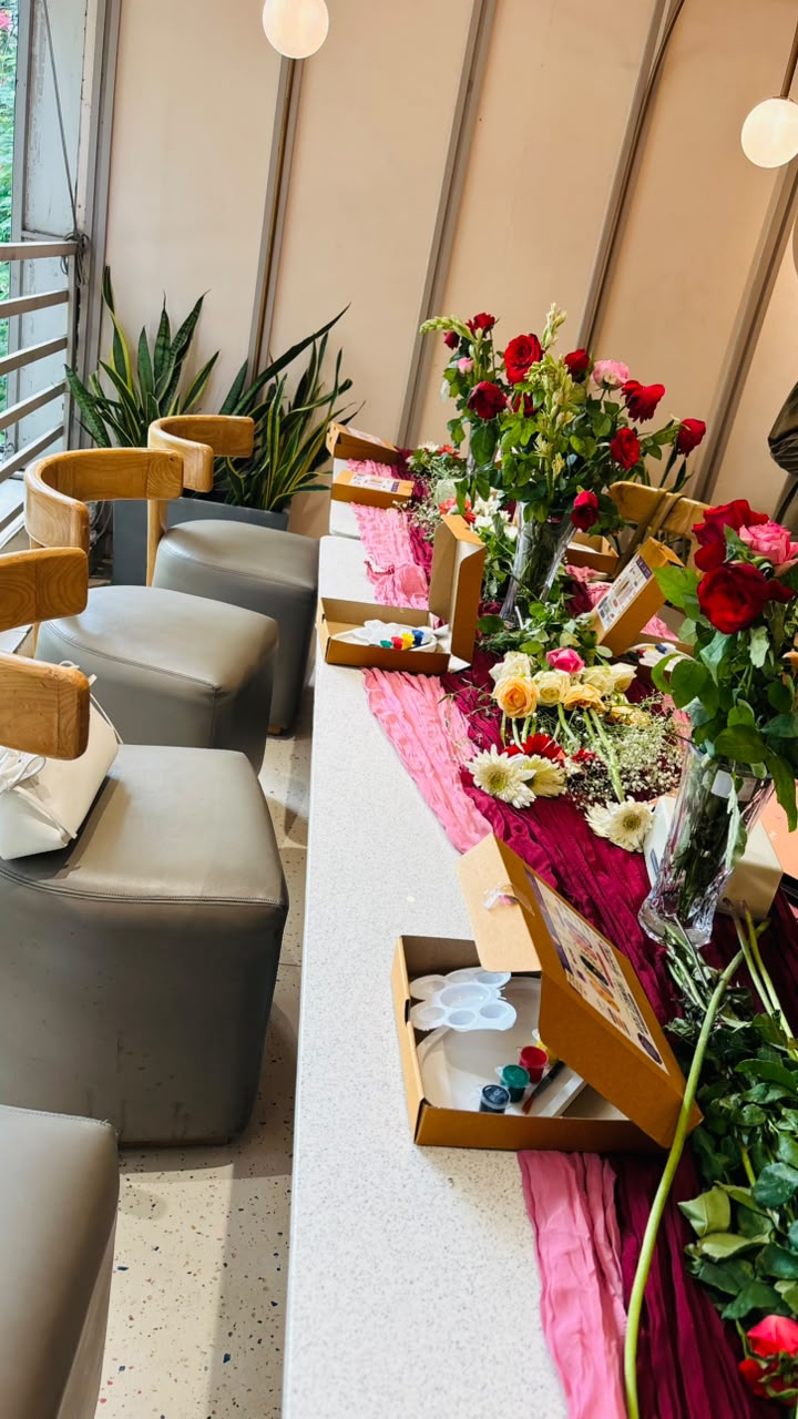 Roses and painting kits on a pink table